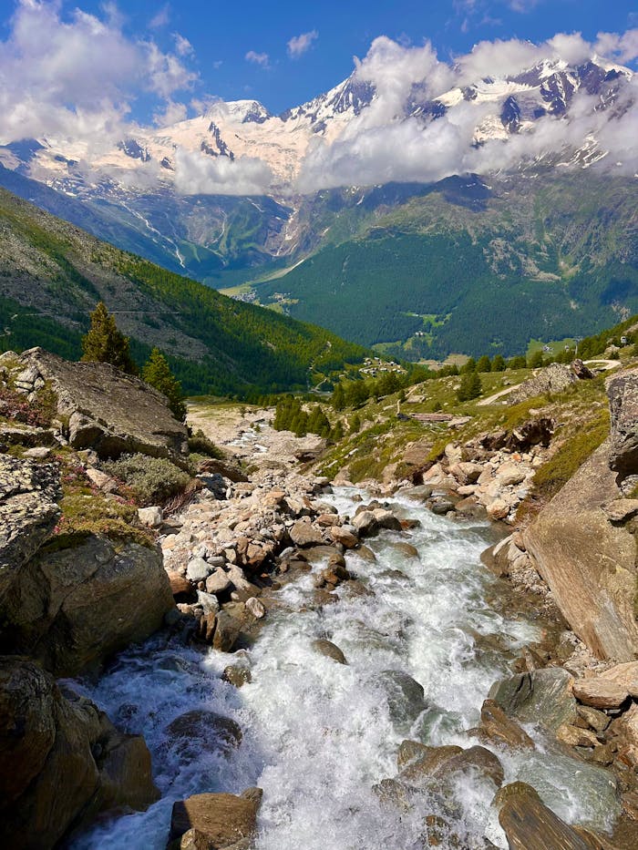 Picturesque alpine stream with mountain backdrop in Saas-Grund, Switzerland.