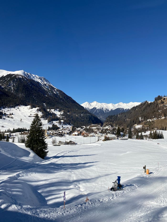 Beautiful snowy scene of Swiss Alps with clear blue sky and mountainous backdrop.